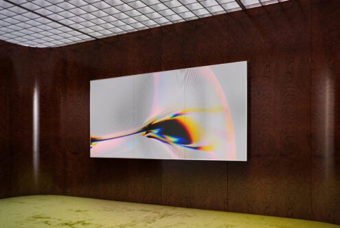 Large gallery display screen showing vibrant rainbow light refraction with flowing lines on dark wood walls