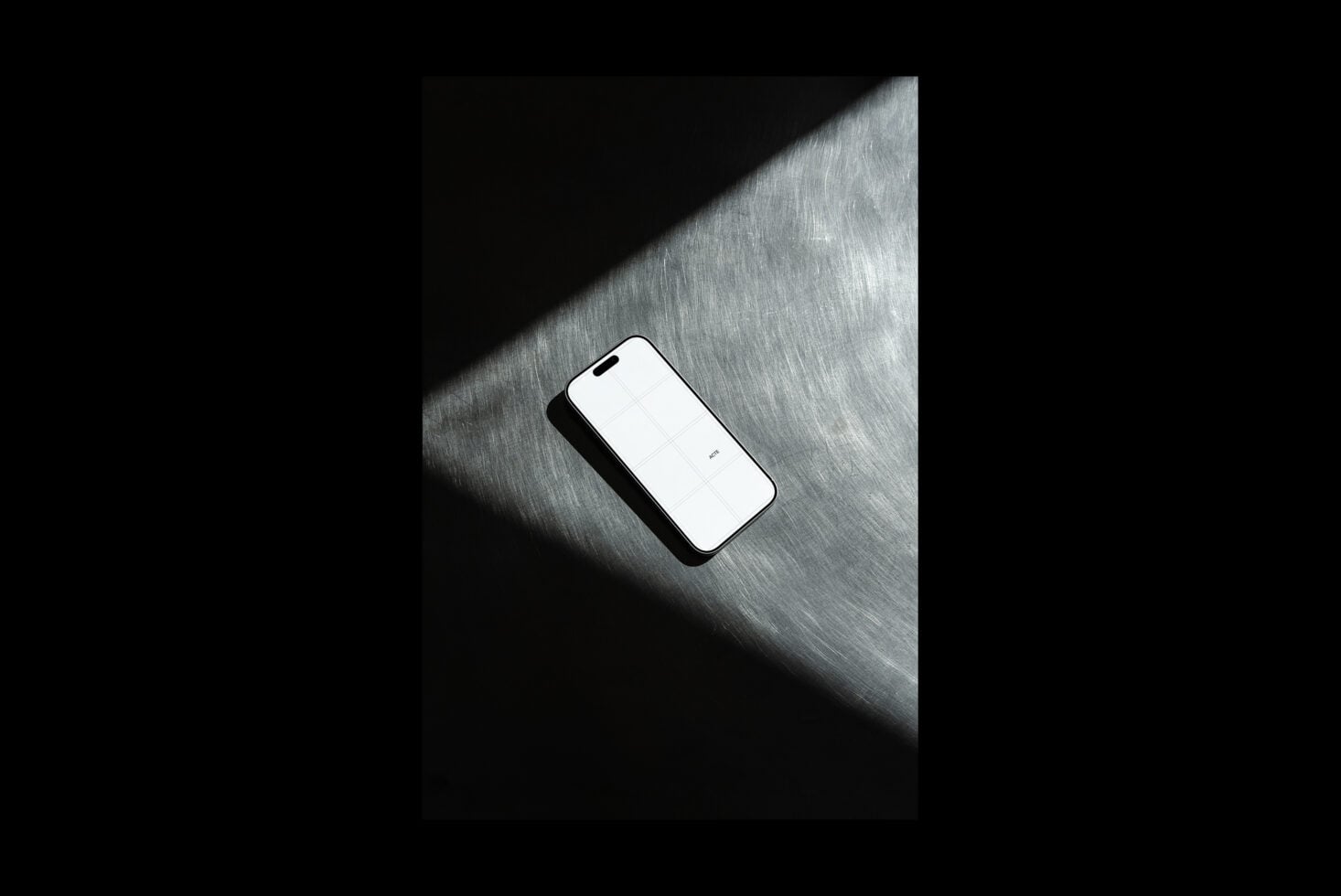 iPhone mockup on brushed metal surface with dramatic window light casting shadows