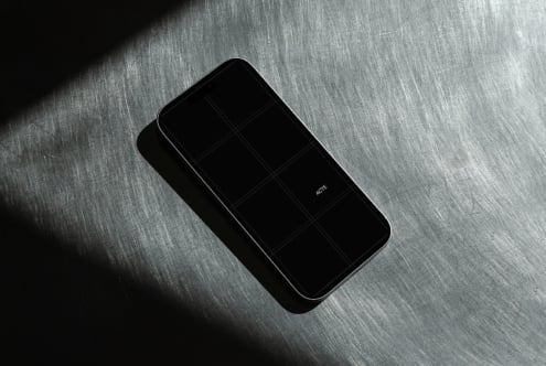 Sleek phone mockup with case on brushed metal surface, dramatic lighting