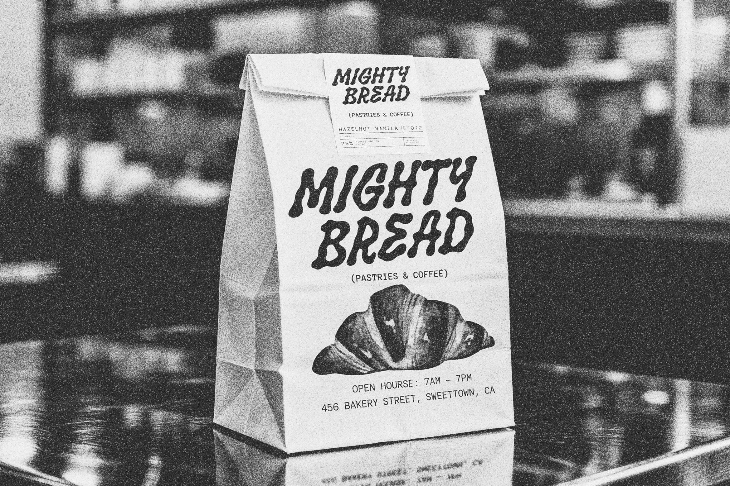 Bakery paper bag mockup with bold hand-drawn lettering for "Mighty Bread" branding on white kraft bag