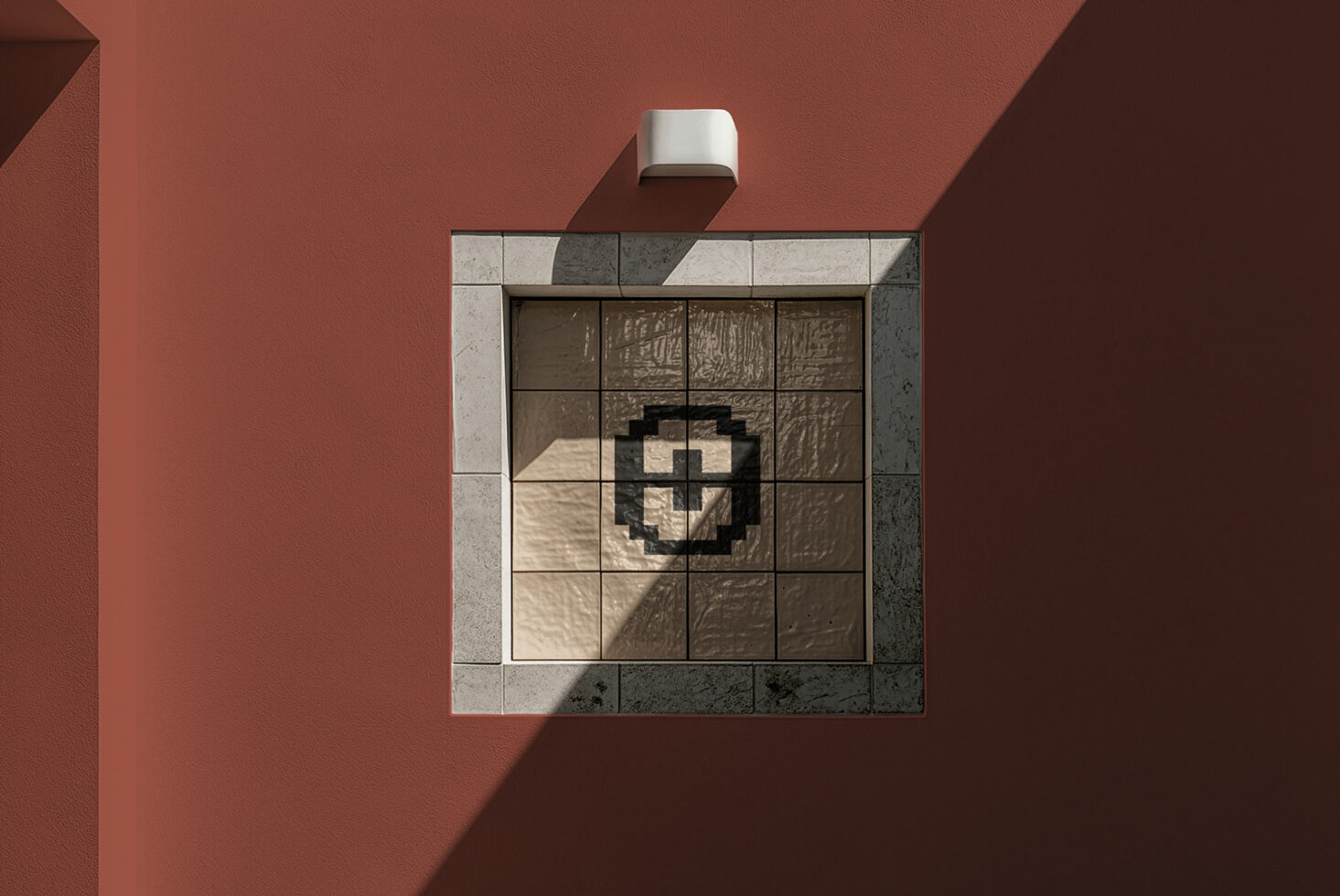 Overhead shot of modern bathroom mirror mounted on terracotta wall with geometric tile surround