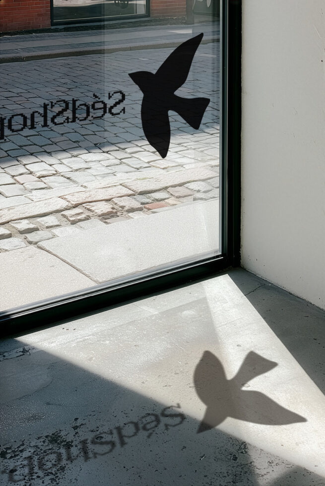 Window decal mockup with arrow shape casting shadow on storefront glass