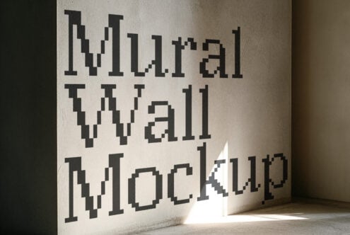 Pixelated retro text carved into concrete wall with dramatic window light casting shadows