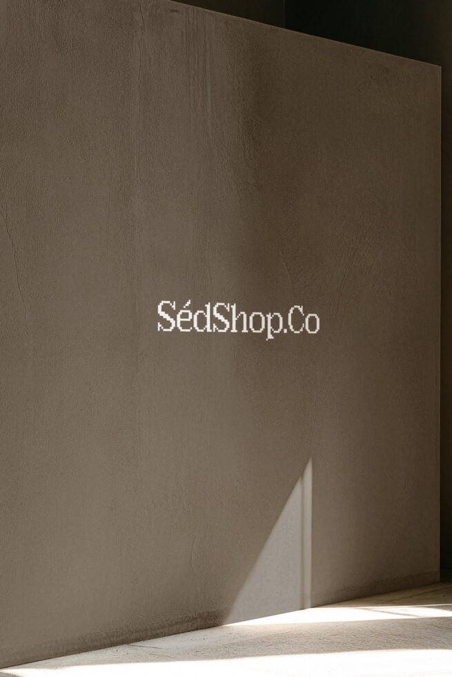 Minimal concrete wall mockup with white logo text, sharp shadow detail, neutral background