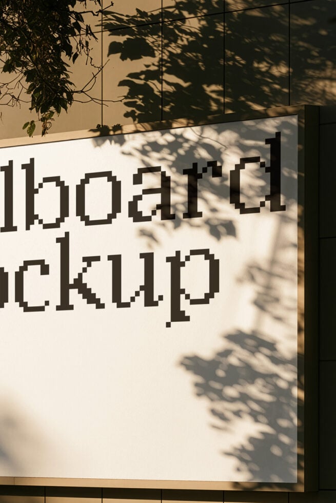 Pixel font on white wall with dappled leaf shadows casting across it