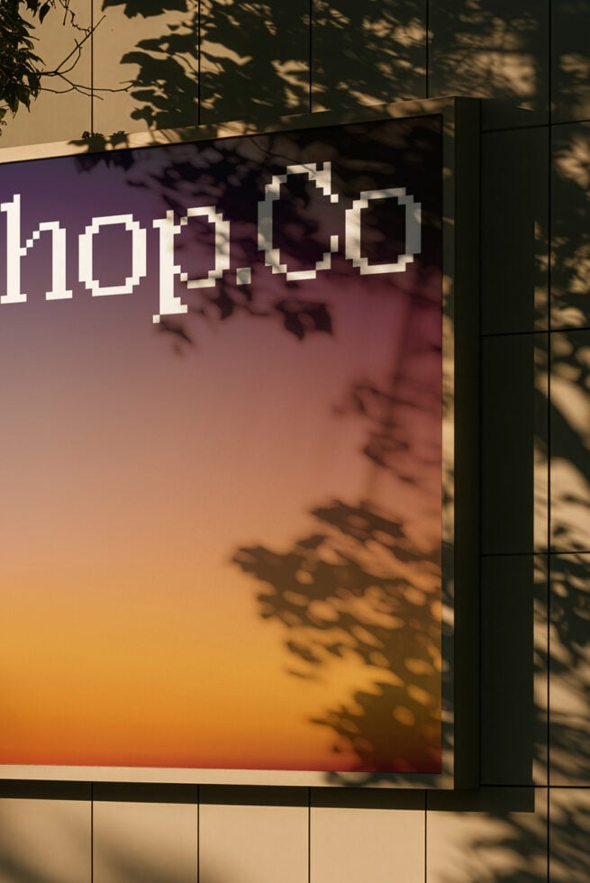 Pixelated text on gradient billboard with leaf shadows cast across it