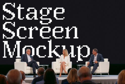 Stage screen mockup with three panelists seated on white chairs during conference discussion
