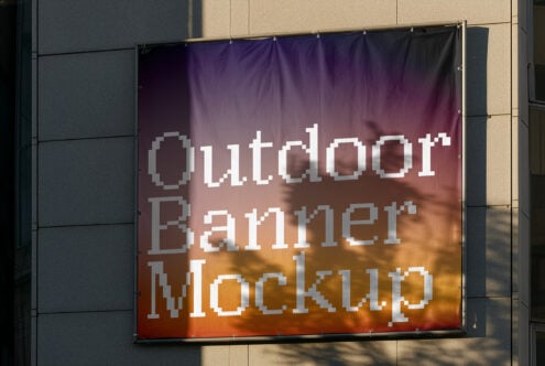 Pixelated text on fabric banner with gradient from purple to orange against building facade