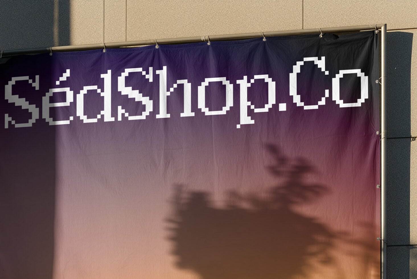 Pixelated white text on purple gradient banner hung on concrete wall with shadows