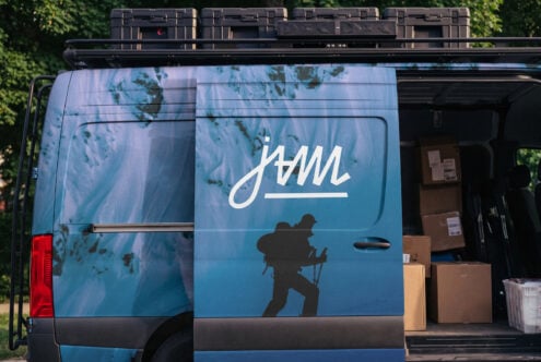 Van wrap mockup with adventure branding, blue gradient background, hiker silhouette, white script logo