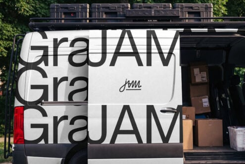 Van wrap mockup with bold geometric type, cargo boxes stacked inside, black roof rack with cases