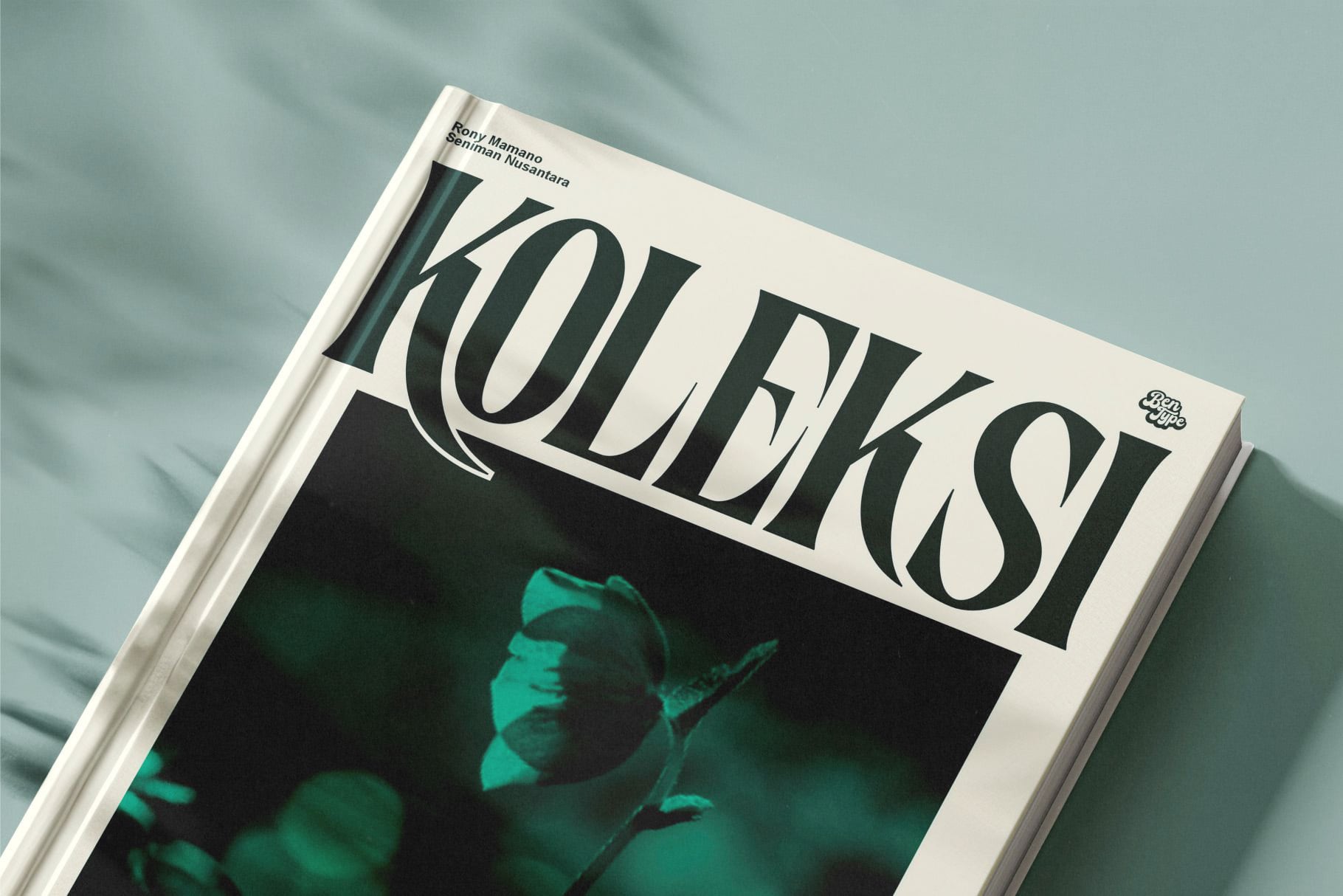 Magazine cover mockup with serif typography, cream background, emerald photo detail, styled on soft blue surface