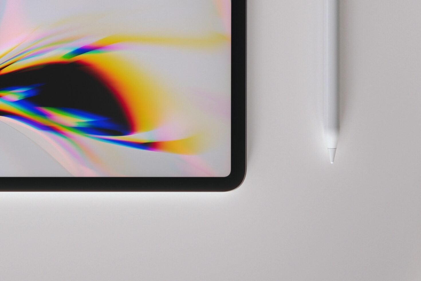 Tablet displaying vibrant rainbow light refraction with stylus nearby