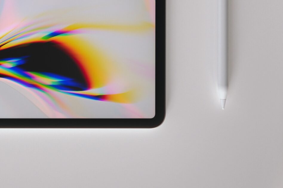 Tablet displaying vibrant rainbow light refraction with stylus nearby