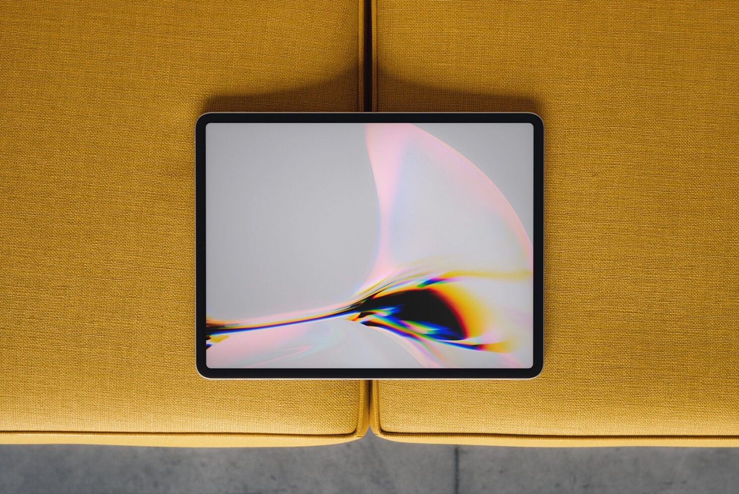 Tablet mockup with chromatic aberration wallpaper on mustard yellow sofa background
