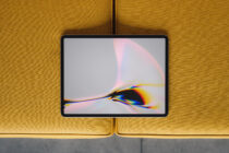 Tablet mockup with chromatic aberration wallpaper on mustard yellow sofa background