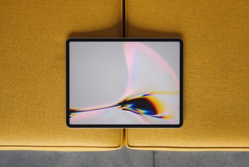 Tablet mockup with chromatic aberration wallpaper on mustard yellow sofa background