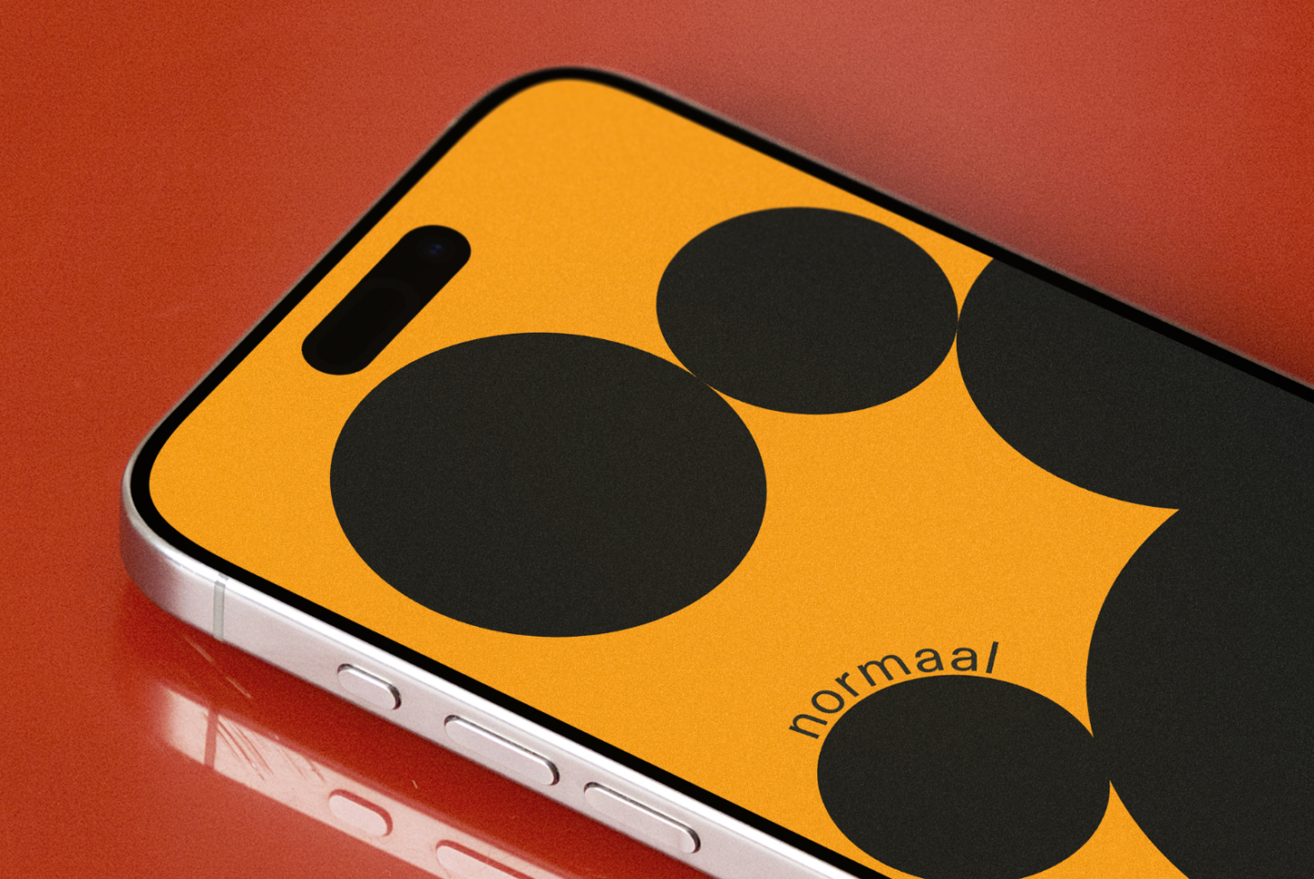 Bright yellow iPhone case with bold black circles on rust background, silver phone edge visible