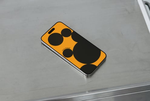 Bold yellow phone mockup with black circle design on gray surface