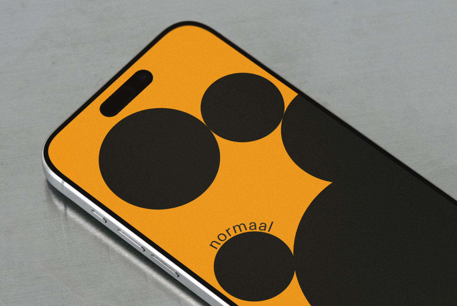 Bright yellow phone case with bold black circles, normaal branding visible on device