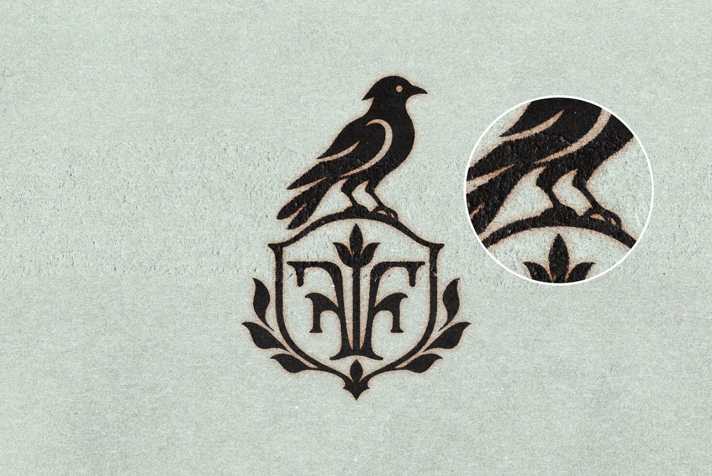Vintage bird crest logo with ornamental shield on textured paper, close-up detail shown