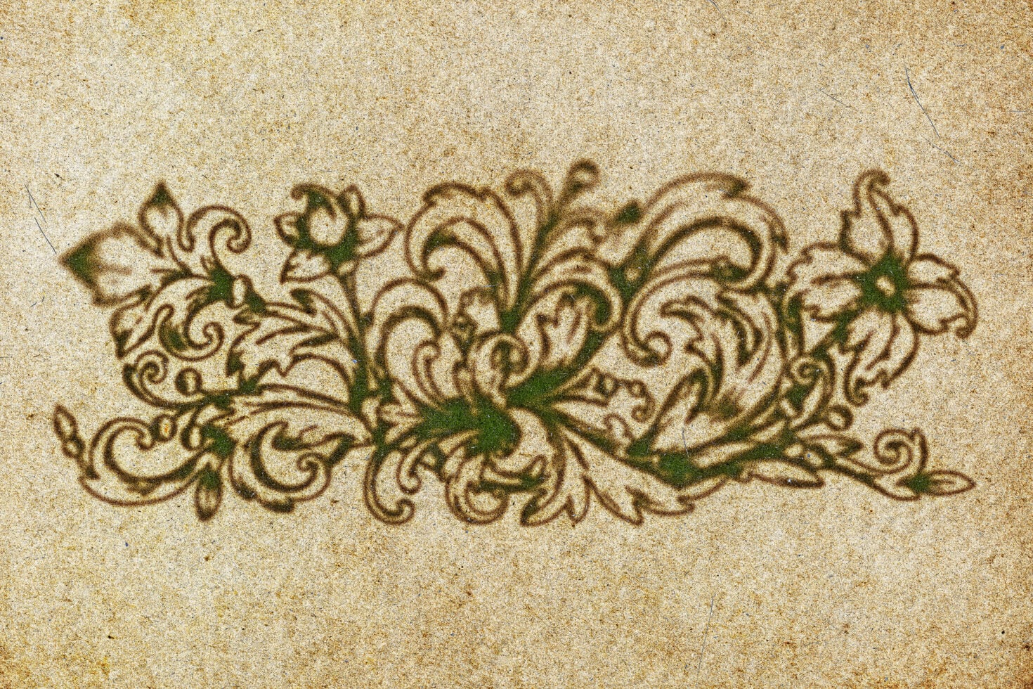 Ornate vintage floral flourish with swirling leaves stamped on aged beige paper texture