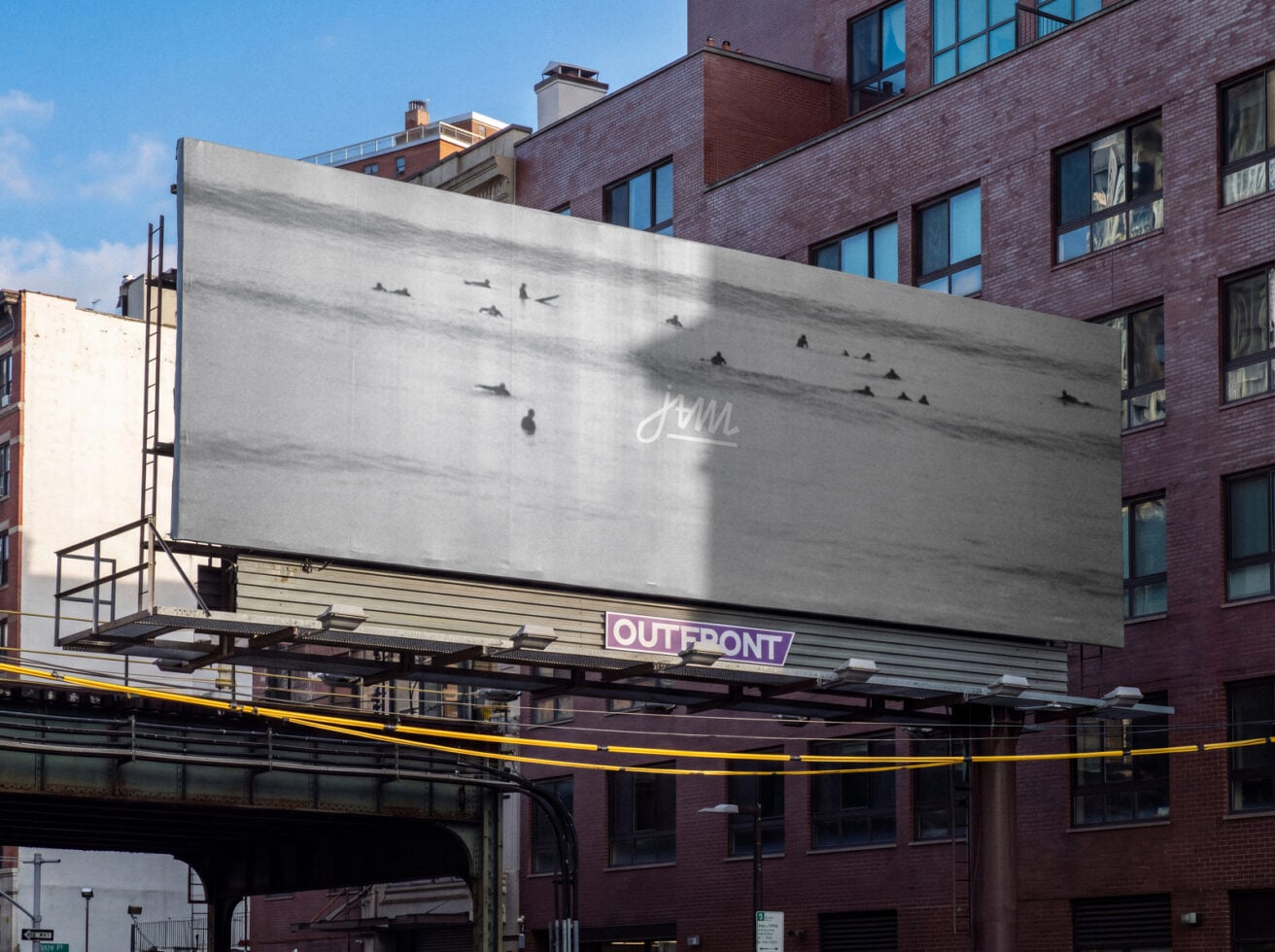 Billboard mockup on urban brick building with cursive script logo, birds in flight, Outfront branding strip below
