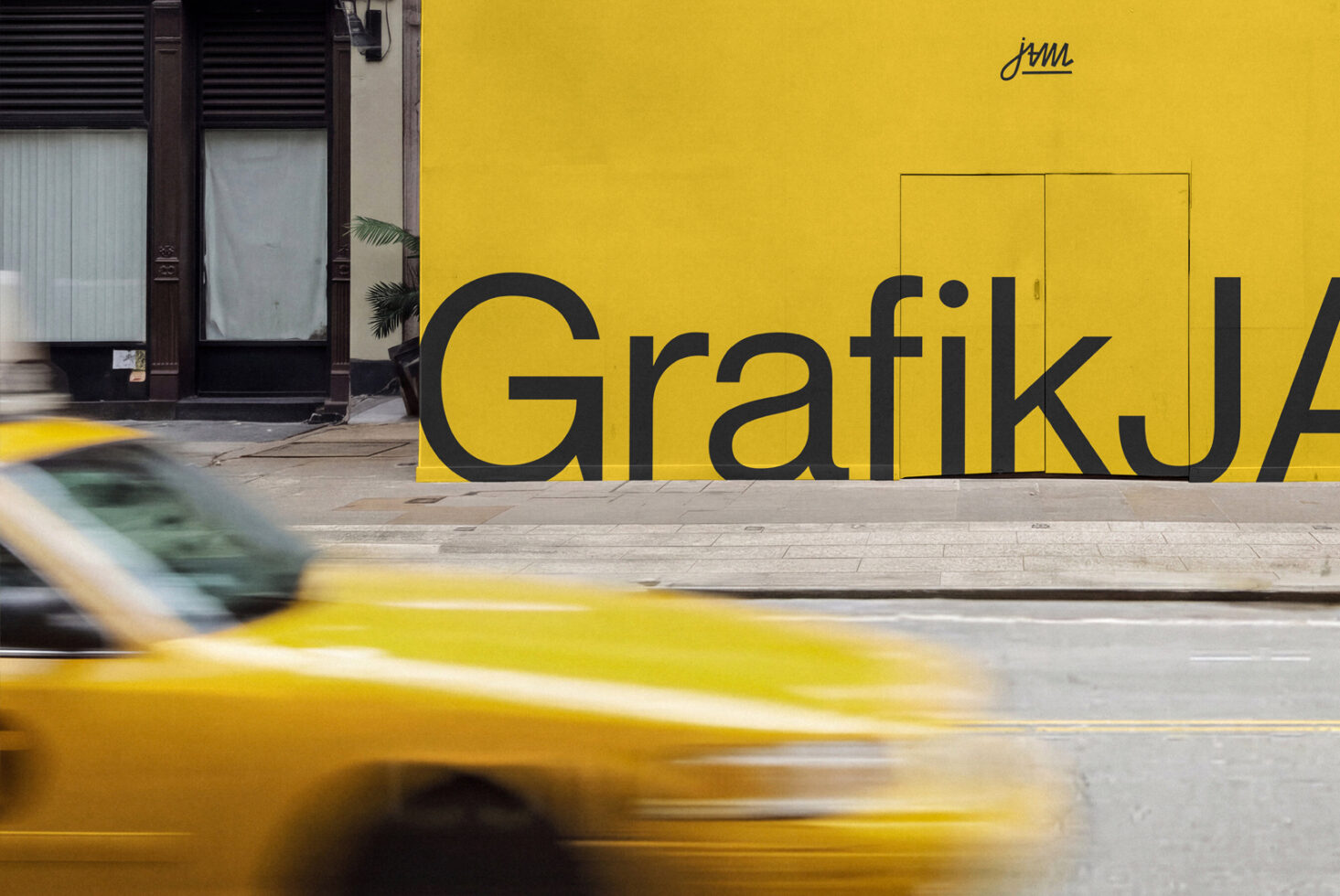 Yellow storefront with bold black lettering, taxi cab motion blur, urban street scene