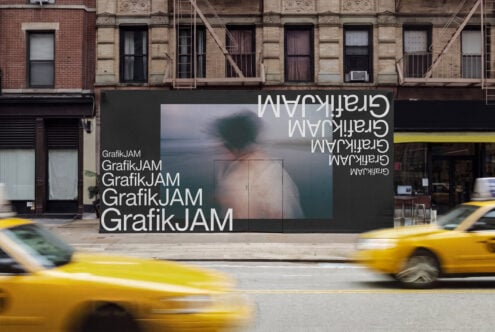 Dark storefront billboard mockup with repeated text, moody image, yellow cabs passing by