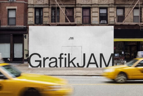 Storefront mockup showing large black typography on white billboard with yellow taxis passing by