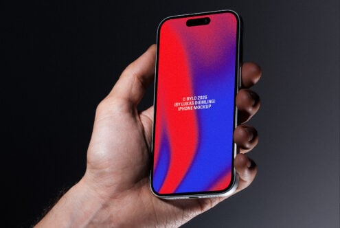 Hand holding iPhone with red to blue gradient display on dark background