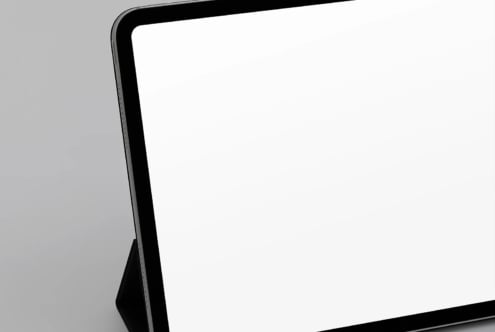 Sleek tablet mockup with black frame on gray background, angled view showing blank screen