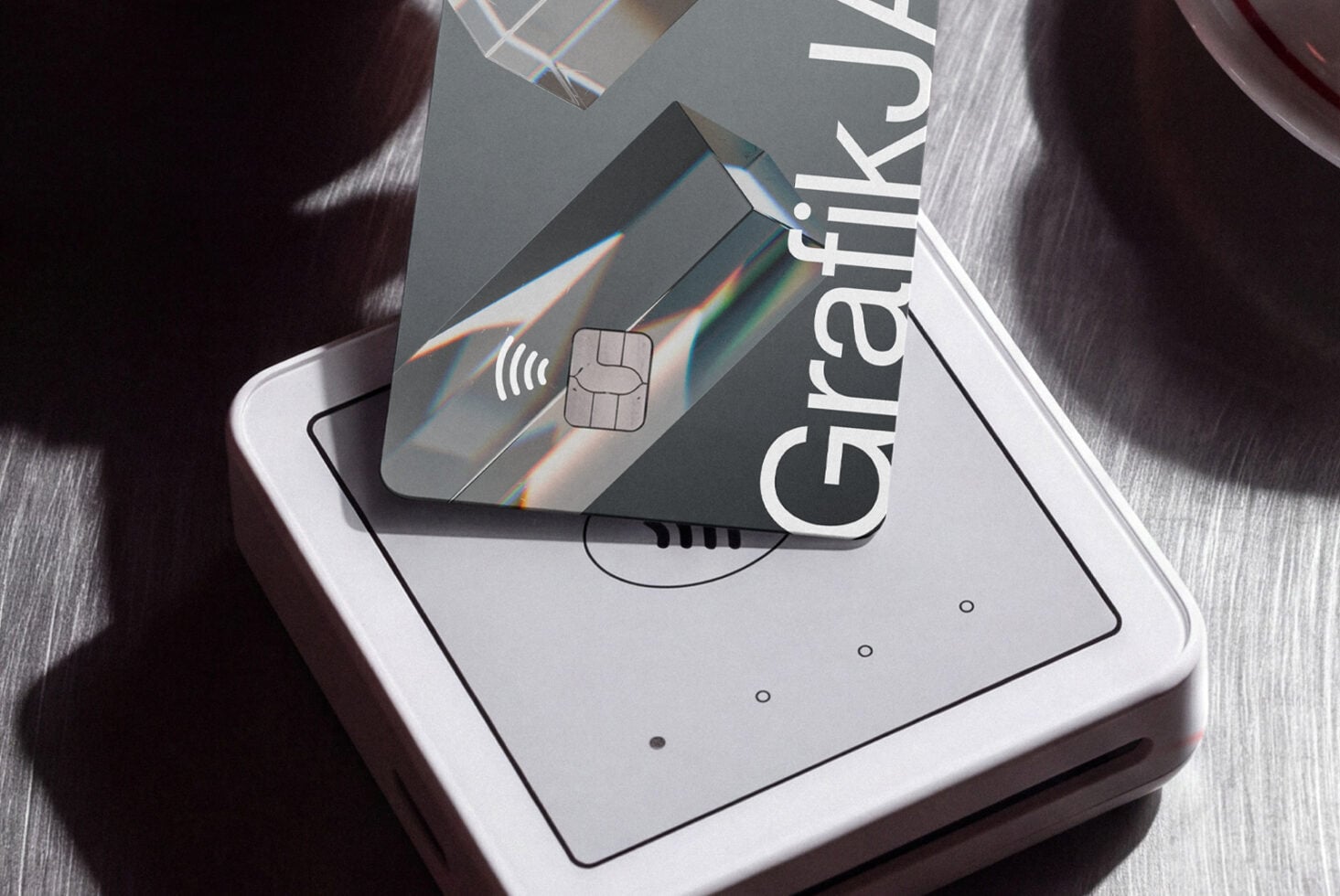 Credit card mockup on phone screen with holographic prism light effects, wireless chip icon visible