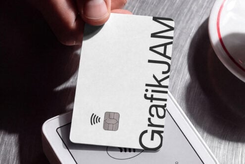 Close-up of hand holding white credit card with contactless chip over payment terminal mockup