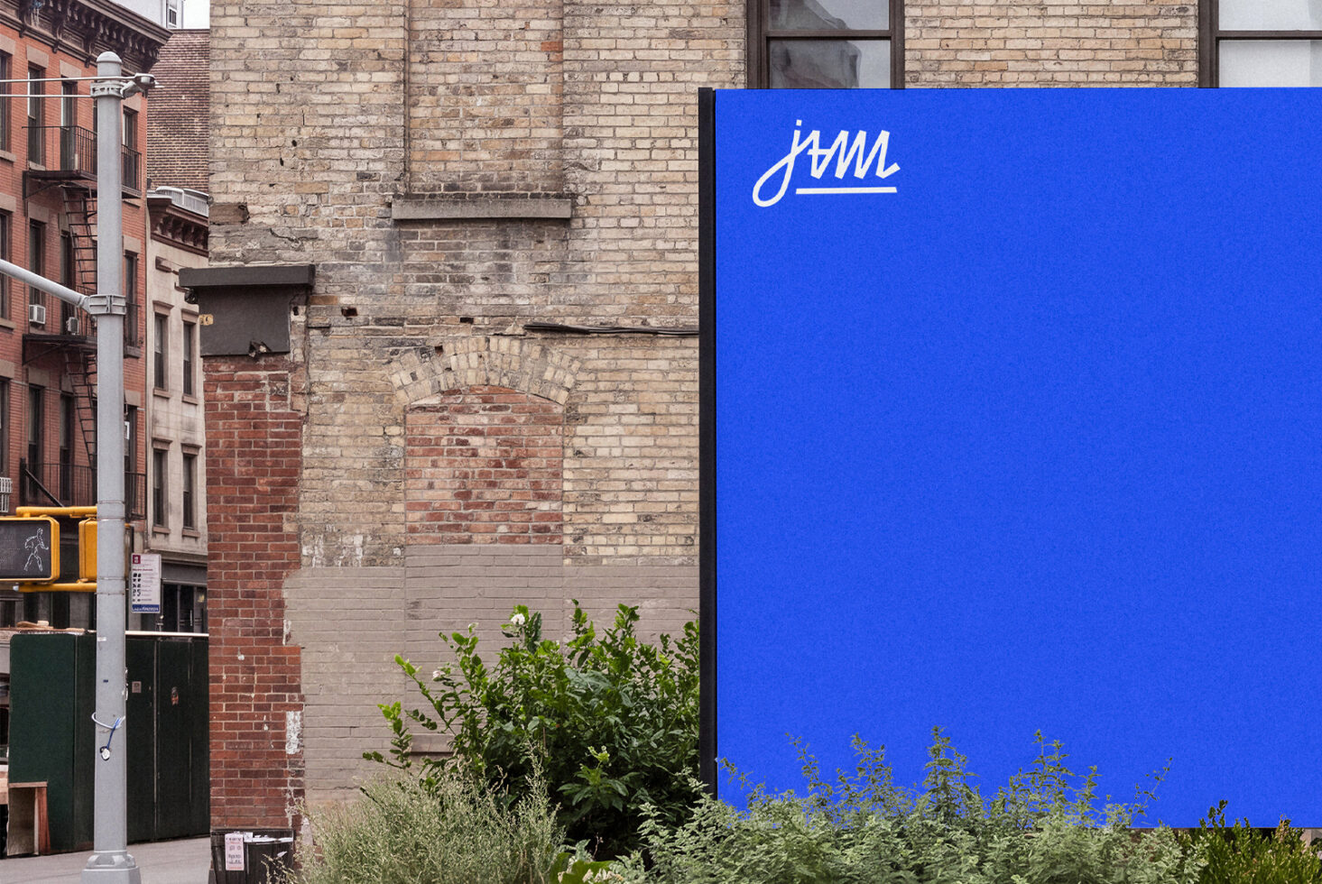 Bright blue billboard with white script logo on gritty brick alley with old buildings