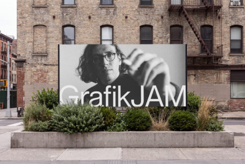 Large outdoor billboard mockup mounted on concrete planter with brick building backdrop