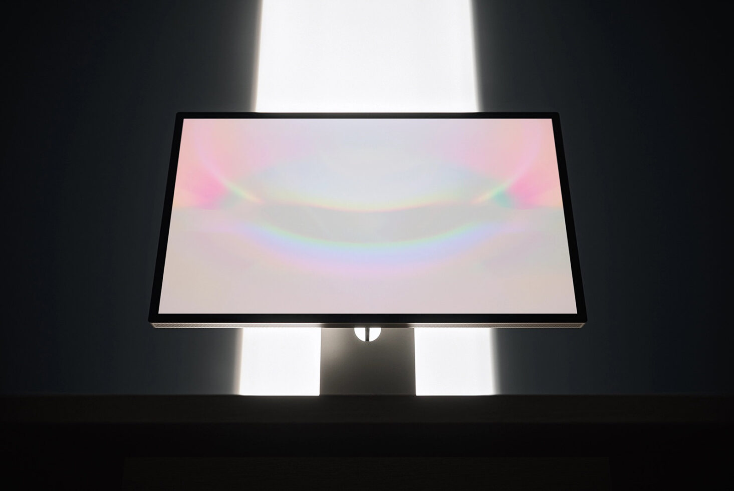 Desktop monitor mockup with soft pastel gradient on screen, dramatic studio lighting