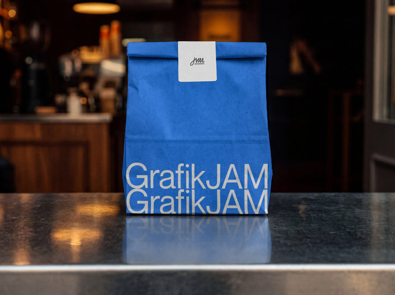 Blue paper bag with white label on dark counter, cafe background out of focus