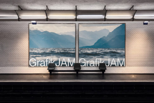 Two large framed landscape photos of mountains meeting water displayed on subway station wall above bench