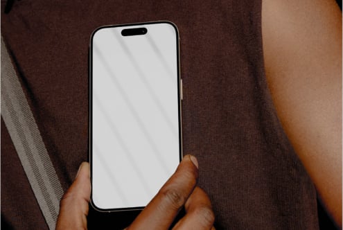 iPhone mockup held in hand against brown fabric background with natural lighting