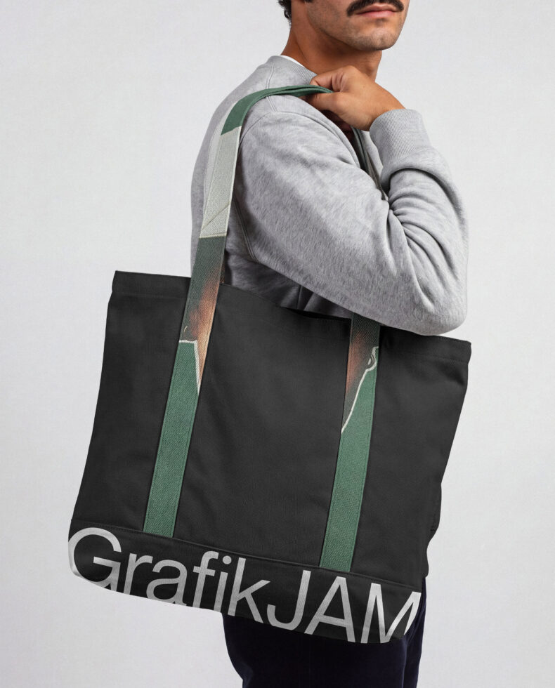 Man wearing gray sweatshirt carrying black tote bag with green straps over shoulder