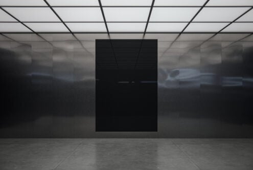 Blank black poster hanging in modern gallery space with grid ceiling