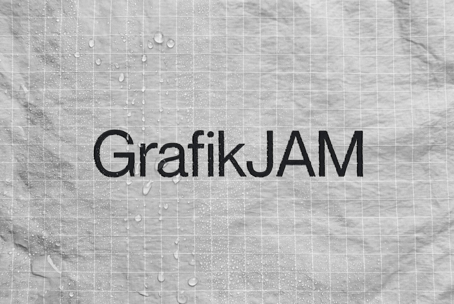 Wet tile surface with water droplets, GrafikJAM text overlay in bold black sans serif font