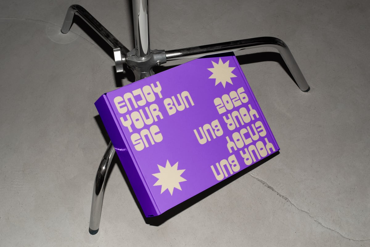 Bright purple book mockup clipped to bike handlebars with yellow text, cream stars, playful retro vibe