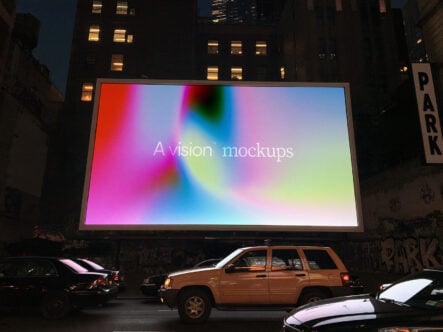 Large outdoor billboard at night displaying vibrant gradient with "A vision mockups" text overlaid, surrounded by parked cars in urban setting