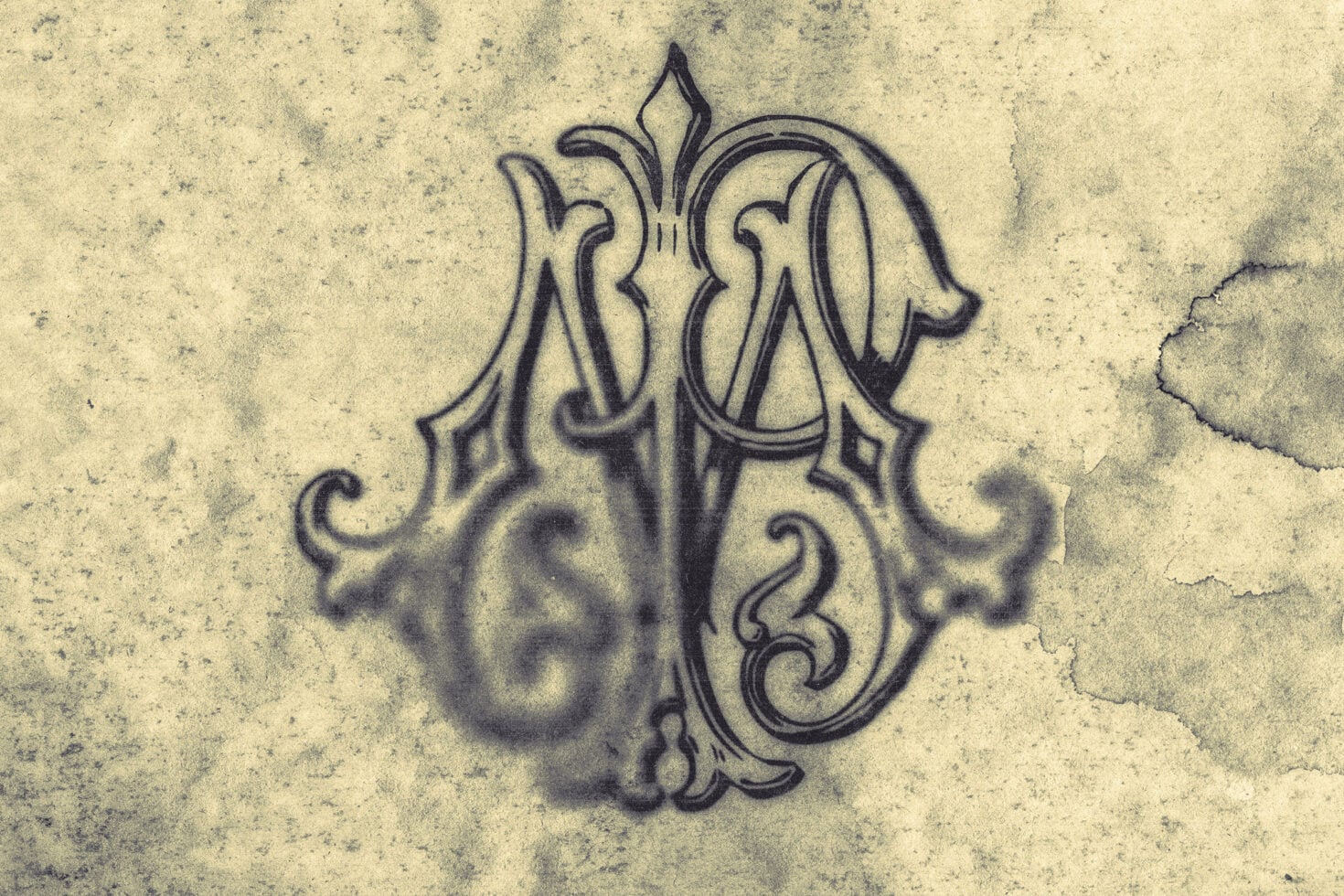 Ornate vintage monogram with flourishing details on distressed aged paper texture