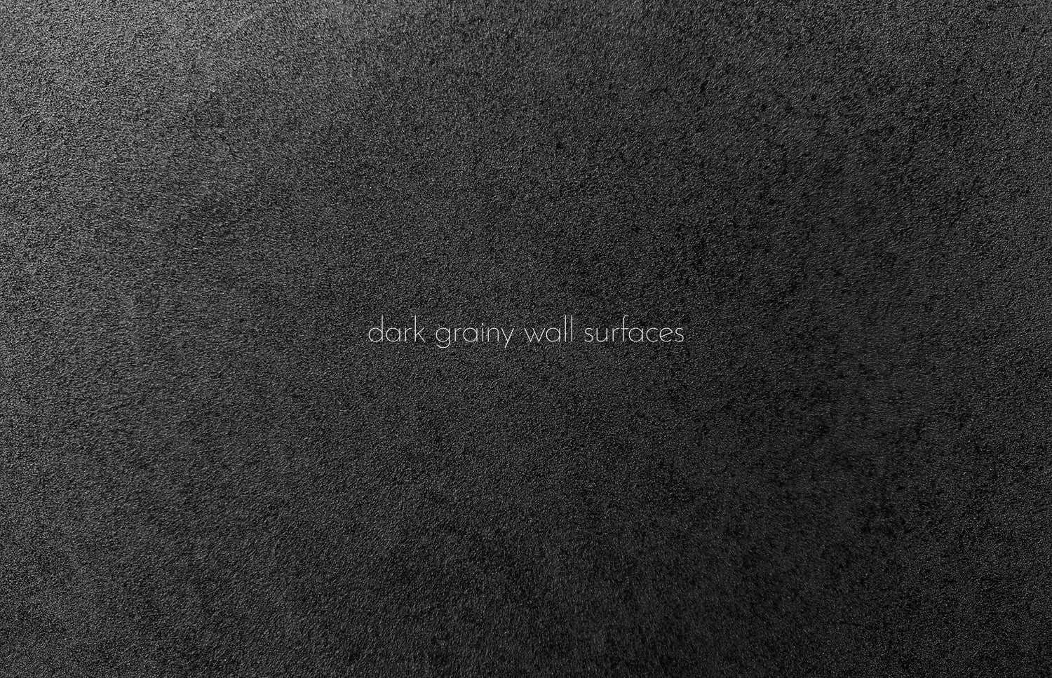 Close-up of rough charcoal concrete wall texture with grainy speckled surface pattern
