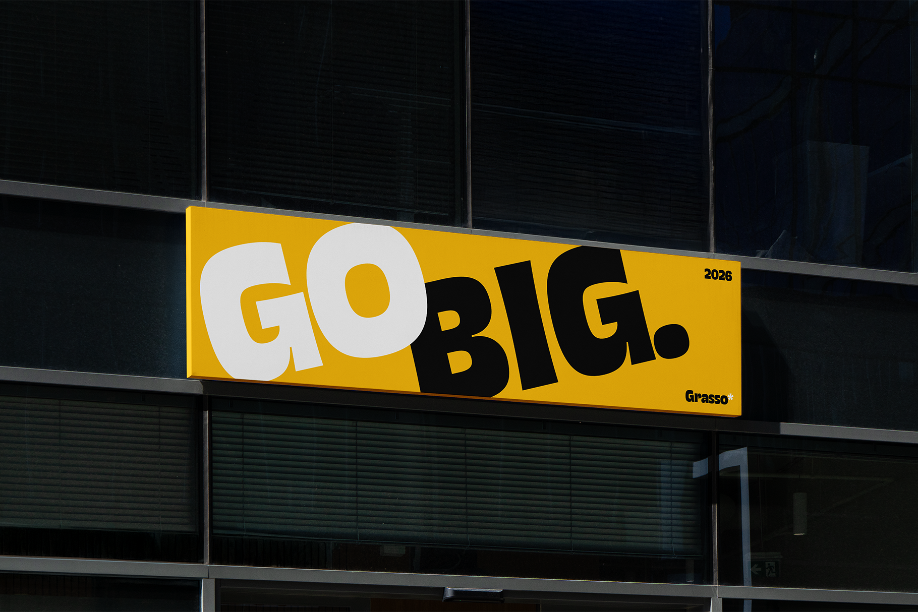 Bright yellow storefront sign with "GO BIG" in bold mixed typography, white, yellow, gold letters against dark urban backdrop