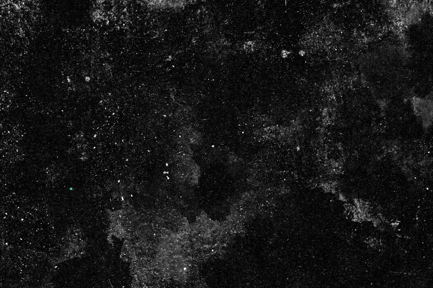 Grungy black texture with white dust particles scattered across dark surface