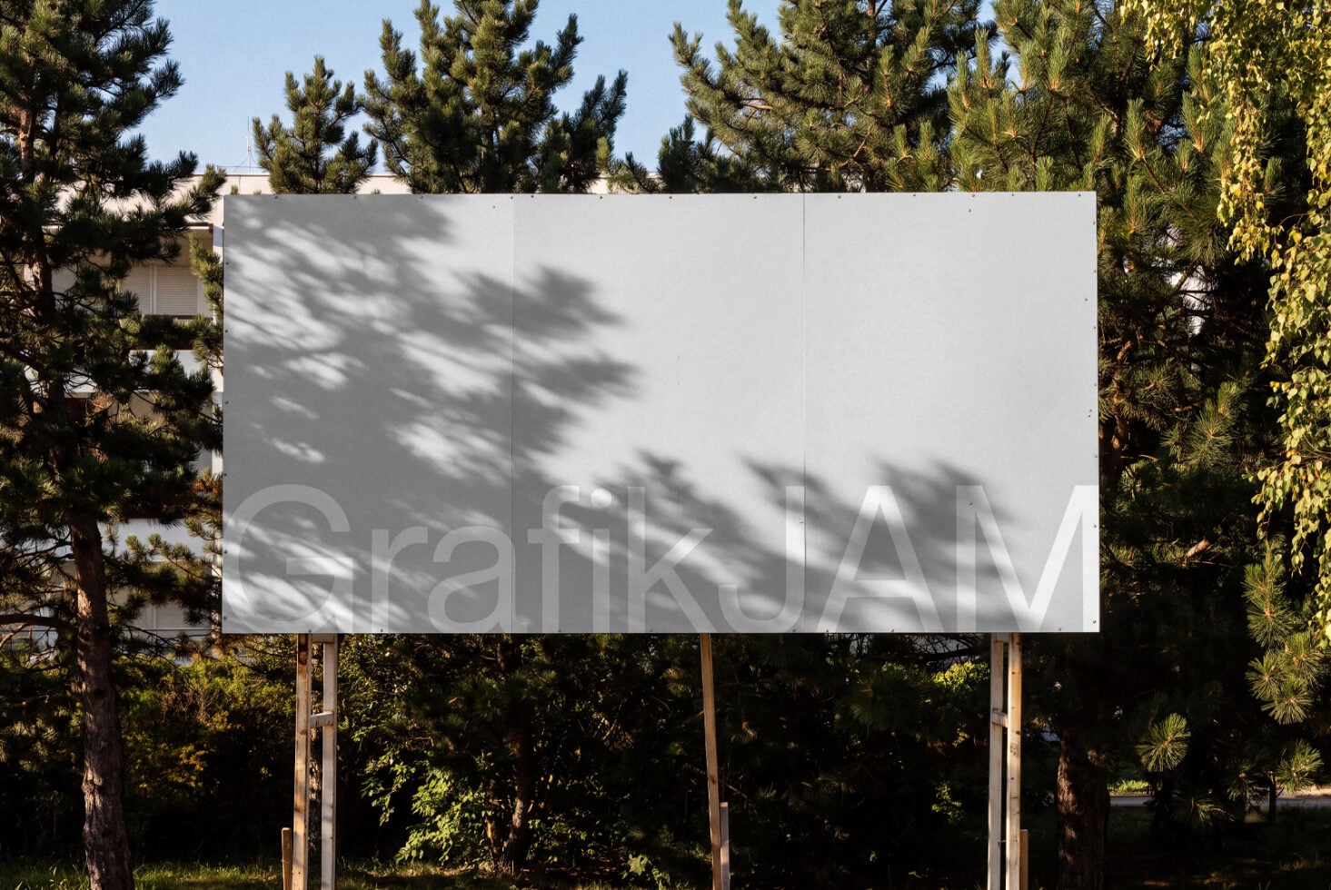 Blank billboard mockup surrounded by pine trees with dappled shadow overlay